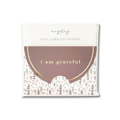 A packet of Maylay Co.'s Lovely Lavender Floral Gift Card Envelopes, featuring a premium matte finish, showcases a brown semi-circle design on the front and gold foil text that reads "I am grateful," all set against a floral pattern on a white background.