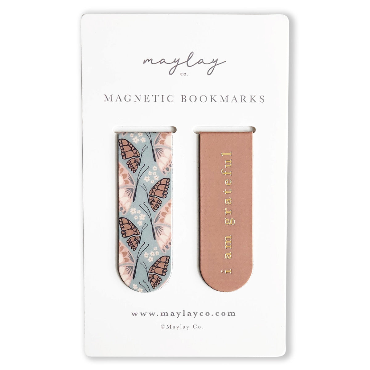 A set of two magnetic bookmarks from Maylay Co., known as the Butterfly Florals Magnetic Bookmarks, is presented on a white card. One bookmark showcases a butterfly and floral design, while the other is pink with "I am grateful" inscribed in gold lettering. These reading companions are ideal gifts for any book lover.