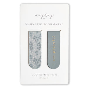 Eucalyptus Floral Magnetic Bookmarks by Maylay Co. offer the ideal companionship for your reading, featuring two stylish magnetic bookmarks on a card. The left bookmark showcases a blue floral pattern, while the right is solid blue with elegant gold text that reads "I am grateful." These thoughtful bookmarks by Maylay Co. ensure your page is marked beautifully and make for an excellent gift.