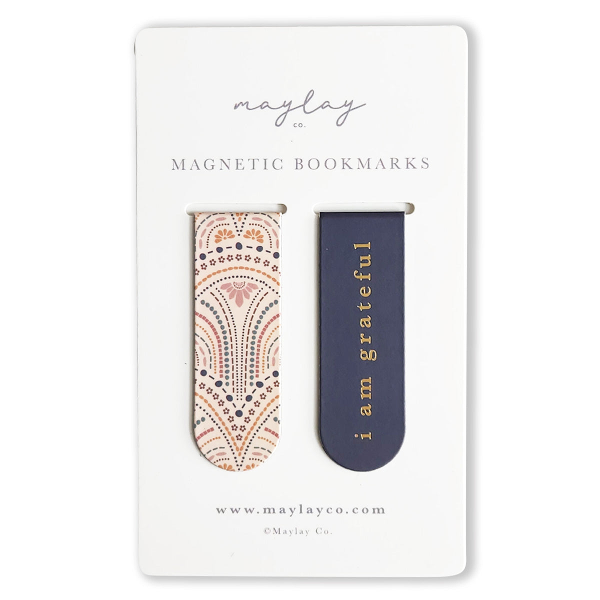 The "So Delicate Magnetic Bookmarks" set by Maylay Co. makes for perfect reading companions, featuring two bookmarks each elegantly displayed on a card. One bookmark showcases a pink and black geometric design, while the other is adorned in navy with the phrase "I am grateful" in gold lettering. These thoughtful gifts come with the card featuring www.maylayco.com.