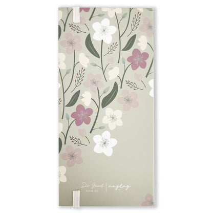 This elegant Enchanted Garden Book of Sticky Notes by Maylay Co. includes a light green cover adorned with a floral pattern of white, pink, and purple flowers amid green leaves. The design is minimalistic and refined, featuring a discreet logo at the bottom.