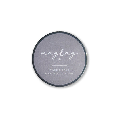 A circular roll of decorative washi tape featuring a dark gray label with the text "Maylay Co., I AM GRATEFUL WASHI TAPE - SLATE BLUE, and www.maylayco.com"—ideal for journaling or scrapbooking enthusiasts.