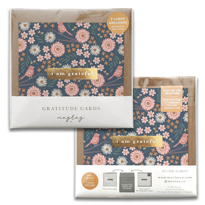 Two sets of Maylay Co.'s Birdy Gratitude Greeting Cards feature a floral and bird design. Each set includes two blank thank you cards, where the dark background enhances the pink and white flowers, with the text elegantly presented in a light color. These cards are perfect for heartfelt greetings.