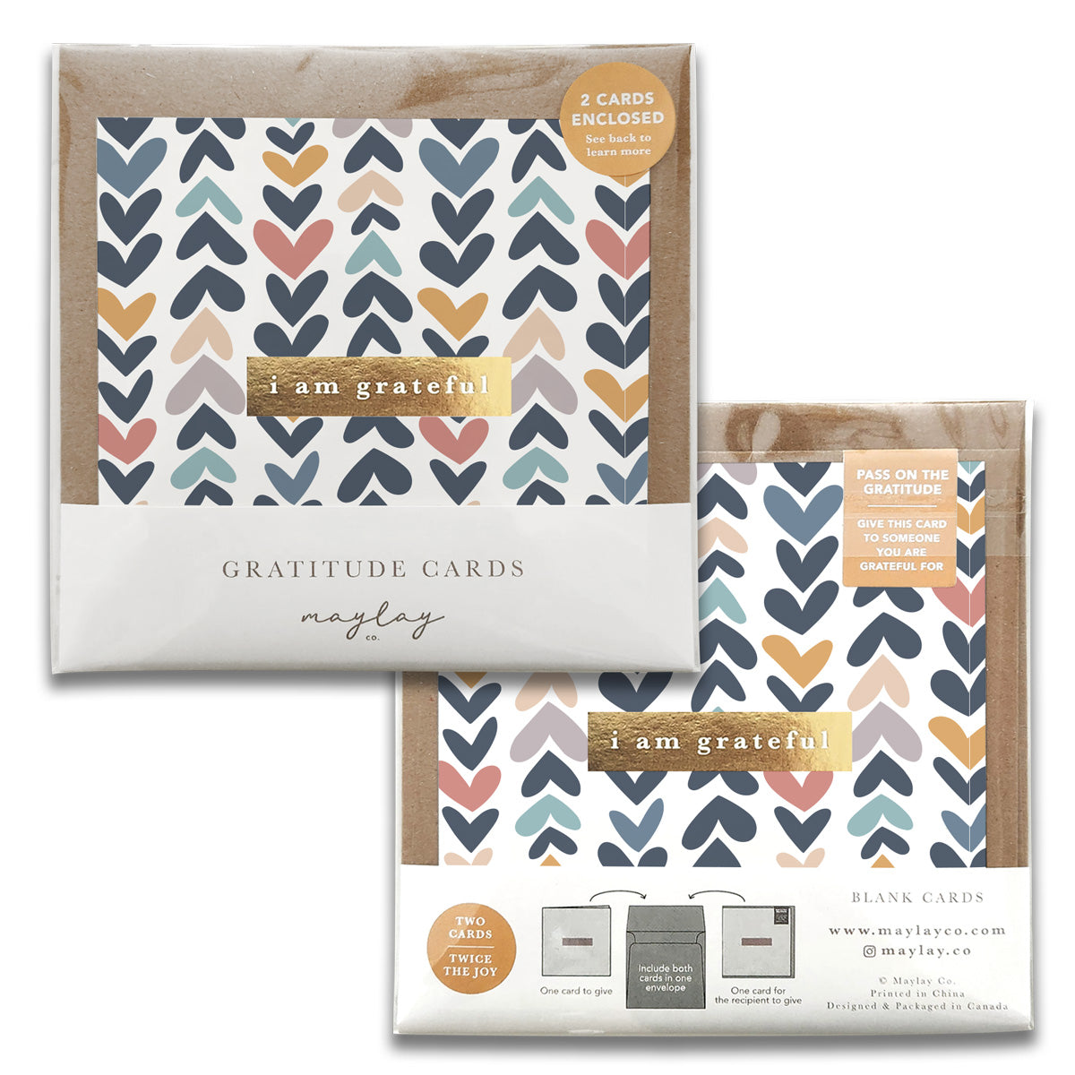 The image showcases two packs of Heartwood Gratitude Greeting Cards by Maylay Co., decorated with heart designs in blue, pink, and mustard on a clean white backdrop. Each pack includes two meaningful greeting cards featuring the phrase "I am grateful" along with guidance for expressing gratitude.