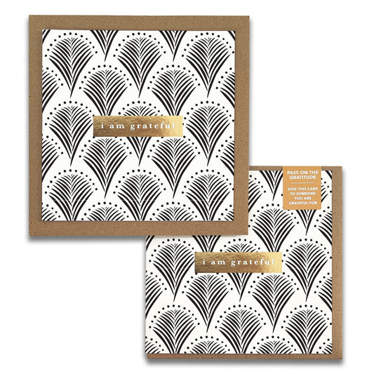 Introducing the Lavish Monochrome Gratitude Greeting Cards by Maylay Co., showcasing a striking black and white geometric pattern with fan shapes and dotted accents. These cards feature the heartfelt message "I am grateful" elegantly displayed on a luxurious gold rectangular label. Each card is complemented by a sophisticated brown border and comes with an accompanying envelope, making it an excellent choice for conveying your deepest thanks.