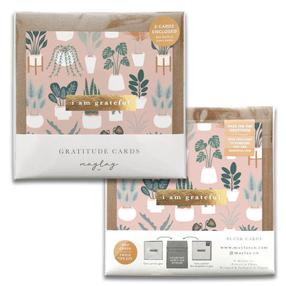 Maylay Co.'s Plant Lover Gratitude Greeting Cards feature a lovely botanical design of potted plants set against a pink background and are adorned with gold accents. The front of the card showcases the phrase "I am grateful." Each pack includes two charming thank you cards, leaving plenty of space for your personal messages.