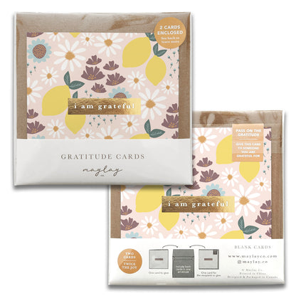 Displayed are two sets of Maylay Co.'s Refreshing Gratitude Greeting Cards, featuring elegant floral and lemon designs. Each set includes greeting cards with matching envelopes and messages such as "I am grateful" and "Pass on the gratitude," making them perfect for expressing a heartfelt thank you.