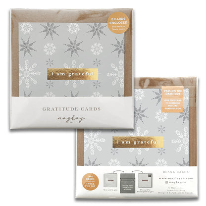 Introducing the Snowflakes Gratitude Greeting Cards by Maylay Co., a set of sophisticated cards showcasing detailed snowflake artwork. Each piece carries the heartfelt message, "I am grateful." The package comes with two greeting cards and coordinating envelopes, with our website details discreetly printed at the bottom.