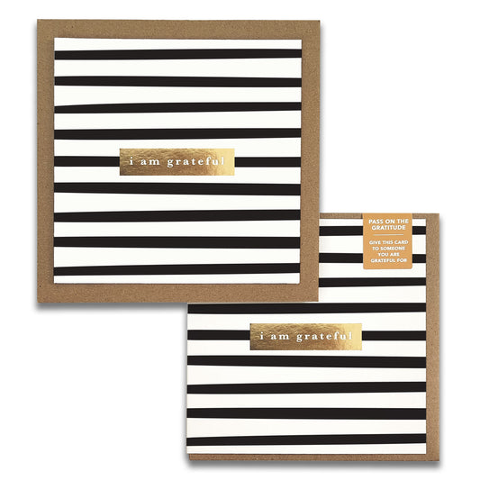 The Stripes Monochrome Gratitude Greeting Cards by Maylay Co. showcase square cards with black and white horizontal stripes, complemented by a gold label that reads "I am grateful." An open card reveals the same sophisticated design inside. Ideal for expressing gratitude, these cards include a small note encouraging you to share them as heartfelt tokens of thanks.