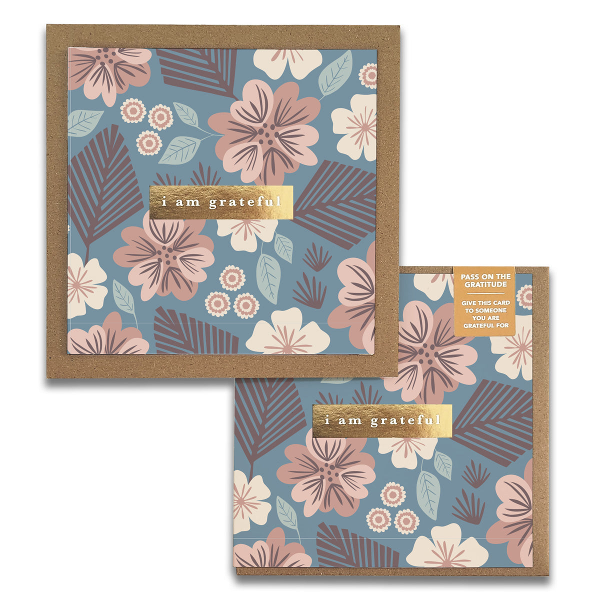 The Tropic Garden Gratitude Greeting Cards by Maylay Co. showcase two designs adorned with pink, blue, and white floral patterns. Each card is elegantly bordered with brown paper and features the phrase "i am grateful" in gold lettering against a gentle backdrop. A small label invites you to share your gratitude forward.