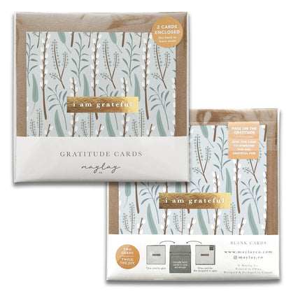 Two packs of Winter Flora Floral Gratitude Greeting Cards by Maylay Co. feature an abstract leaf pattern with the text "I am grateful." One pack includes two cards and a sticker, while the other offers four cards and envelopes. Both packs boast premium quality designs, ensuring a cohesive look and branding.