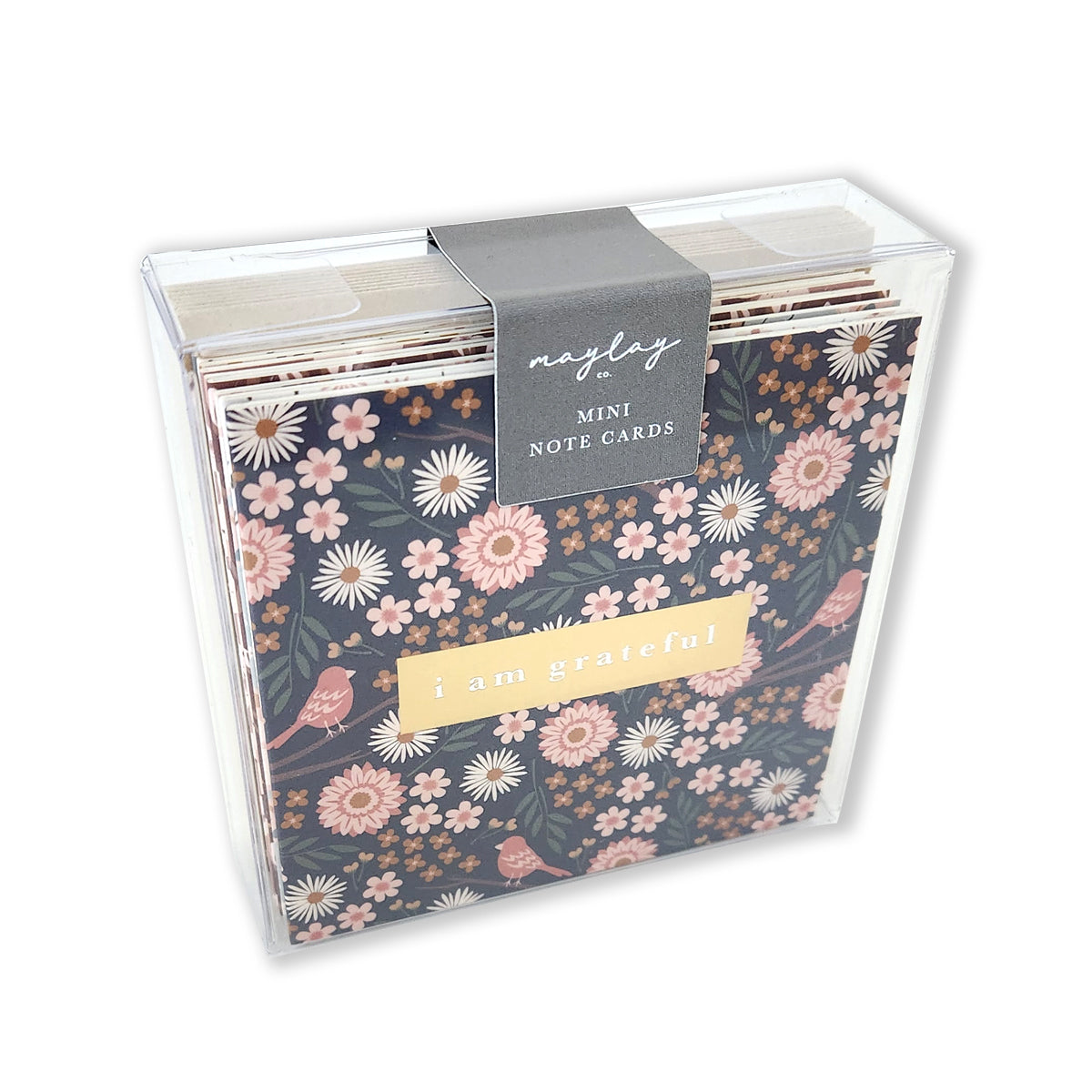 A transparent box containing the premium Florals Gratitude Mini Note Card Set by Maylay Co., featuring mini note cards with pink and white floral designs adorned with birds. The front card has the phrase "I am grateful" elegantly stamped in gold foil. A gray label on top reads Maylay Co. MINI NOTE CARDS, making them perfect as Gratitude Greeting Cards.