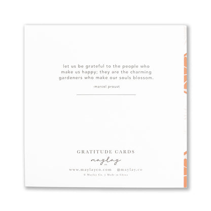 A white Tang Gratitude Greeting Card features an inspirational quote by Marcel Proust: "Let us be grateful to the people who make us happy; they are the charming gardeners who make our souls blossom." Elegantly presented by Maylay Co., it's a heartfelt expression of thanks.