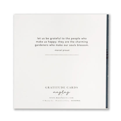 A white greeting card from Maylay Co.'s Wildflowers Gratitude Greeting Cards collection features a quote by Marcel Proust: "Let us be grateful to the people who make us happy; they are the charming gardeners who make our souls blossom.